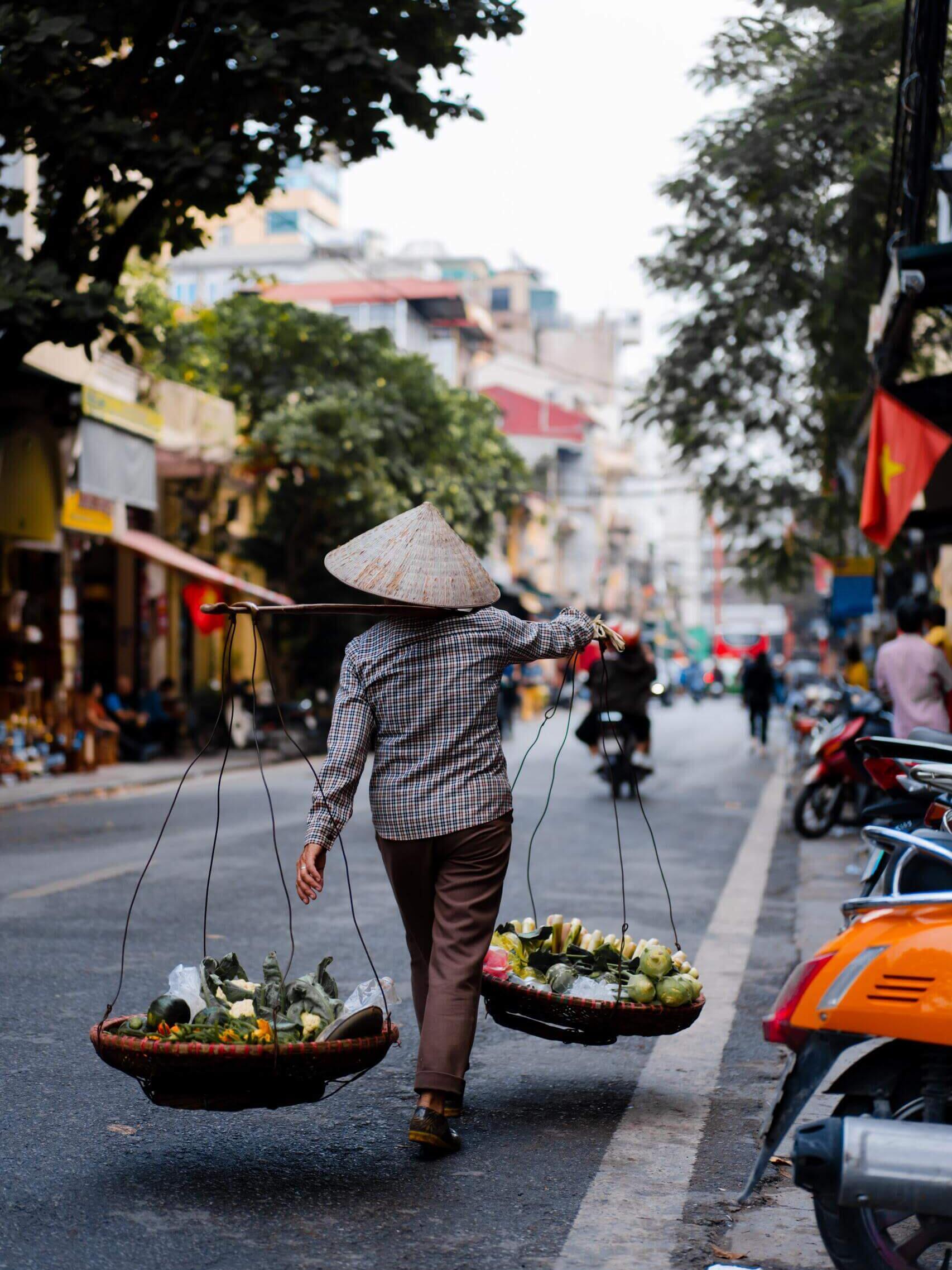 Eine Frau trägt Bastkörbe in Vietnam